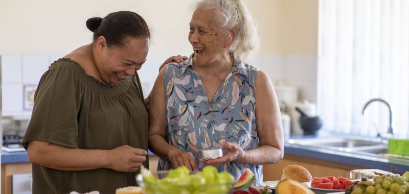 Senior Pacific Islander woman and her mature daughter preparing food together in their kitchen at home.