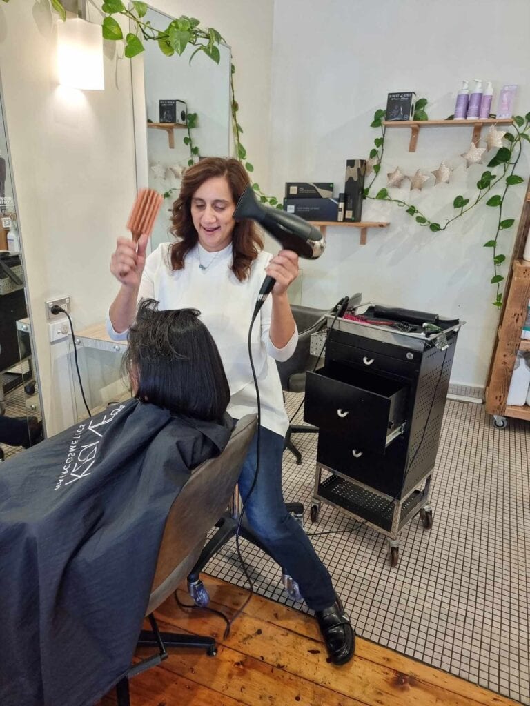 Shabana blow dries a clients hair in her salon.